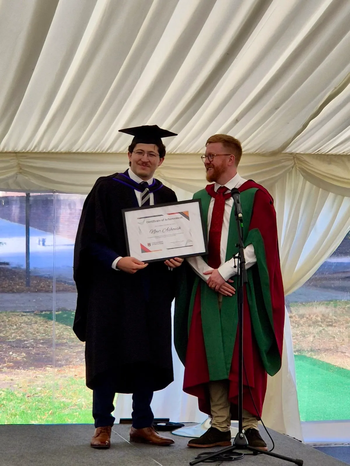 Holding the certificate for the best student in the master's cohort, beside the new head of computer science
