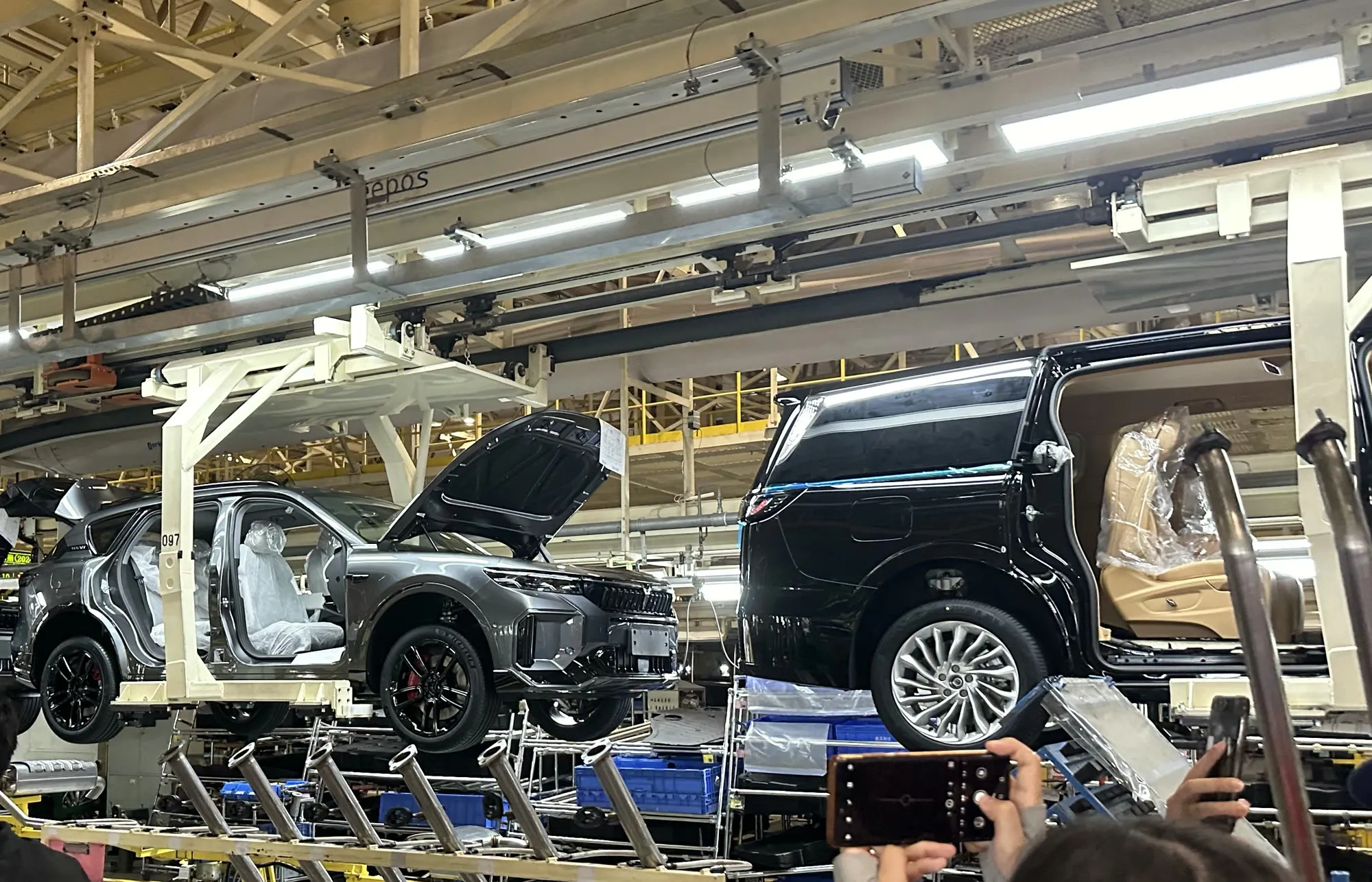 Half-built VOYAH cars moving along the assembly line, doors open and seats still wrapped